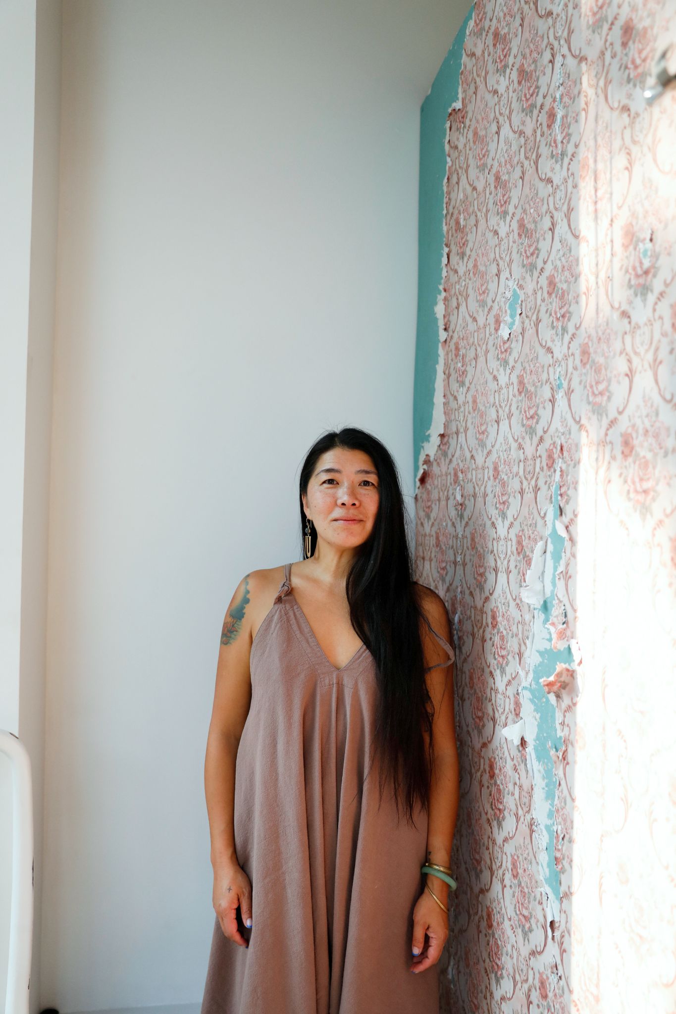 jeanie standing beside a softly patterned wall